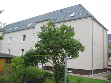 kleines Bild - Hofansicht Brüder-Lang-Straße 12-14 in Bitterfeld hat 10 Wohnungen, 1 + 2 RWE, 34 - 44 m<sup>2</sup>, Fernwärme, Stellplatz oder Garage möglich. Nebengelass in Verbinderbauten bzw. Dachgeschoss. Viel Grün und Gartennutzung möglich. Mehrere Garagenkomplexe im Wohngebiet vorhanden.