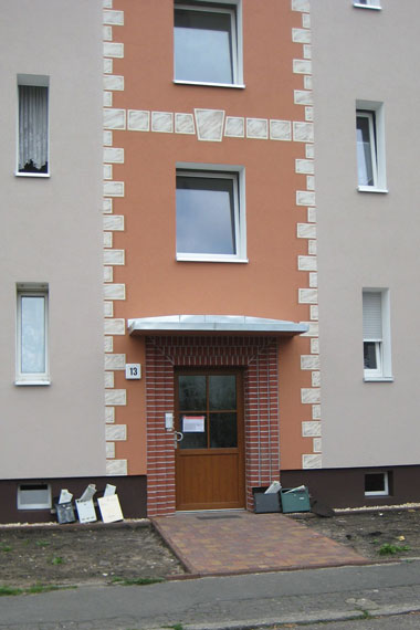 kleines Bild - Eingang 13 Brüder-Lang-Straße 11-13-15 in Bitterfeld hat 16 Wohnungen, 1 + 2 RWE, 33 - 52 m<sup>2</sup>, Fernwärme, Stellplätze möglich. Nebengelass in Verbinderbauten bzw. Dachgeschoss. Viel Grün und Gartennutzung möglich. Mehrere Garagenkomplexe im Wohngebiet vorhanden.