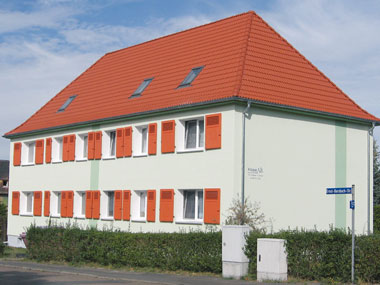 kleines Bild - Straßenansicht Ernst-Borsbach-Straße 1-5 in Bitterfeld hat 4 Wohnungen, 2 RWE, 42 - 63 m<sup>2</sup>, mit viel Grünfläche, Fernwärme, Stellplatz oder Garage möglich. Auch Eigener Garten ist möglich. Nebengelass in Verbinderbauten bzw. Dachgeschoss. Viel Grün und Gartennutzung möglich. Mehrere Garagenkomplexe im Wohngebiet vorhanden.