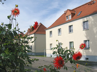 kleines Bild - Hof Ernst-Borsbach-Straße 7-9-11 in Bitterfeld. Die Häuser verfuehgen über je 4 Wohnungen mit 2 RWE, 42 - 49 m<sup>2</sup>, mit viel Gruenflarche, Fernwärme, Stellplatz oder Garage möglich. Auch Eigener Garten ist möglich. Nebengelass in Verbinderbauten bzw. Dachgeschoss. Viel Grün und Gartennutzung möglich. Mehrere Garagenkomplexe im Wohngebiet vorhanden.