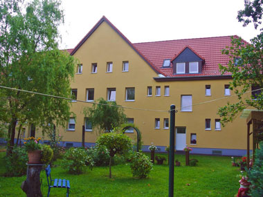 kleines Bild - Garten Otto-Hahn-Platz 8-9 in Bitterfeld hat 10 Wohnungen, 2 RWE, 40 - 49 m<sup>2</sup>, altengerechte Bäder mit bodengleicher Dusche  vorhanden, Fernwärme, Stellplatz oder Garage möglich. Nebengelass in Verbinderbauten bzw. Dachgeschoss. Viel Grün und Gartennutzung möglich. Mehrere Garagenkomplexe im Wohngebiet vorhanden.