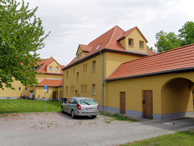 kleines Bild - Hofansicht Ertelstraße 5 in Bitterfeld hat 4 Wohnungen, 1 - 3 RWE, 35 - 65 m<sup>2</sup>, altengerechte Bäder mit bodengleicher Dusche  vorhanden, Fernwärme,  Stellplätze möglich. Nebengelass in Verbinderbauten bzw. Dachgeschoss. Viel Grün und Gartennutzung möglich. Mehrere Garagenkomplexe im Wohngebiet vorhanden.