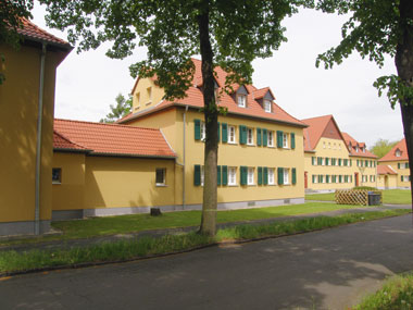 kleines Bild - Hofansicht Otto-Hahn-Platz 7 in Bitterfeld hat 5 Wohnungen, 2 - 4 RWE, 46 - 91 m<sup>2</sup>, altengerechte Bäder mit bodengleicher Dusche  vorhanden, Fernwärme, Stellplätze möglich. Nebengelass in Verbinderbauten bzw. Dachgeschoss. Viel Grün und Gartennutzung möglich. Mehrere Garagenkomplexe im Wohngebiet vorhanden.