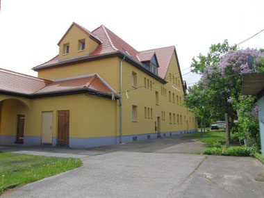 kleines Bild - Hofansicht Otto-Hahn-Platz 8-9 in Bitterfeld hat 10 Wohnungen, 2 RWE, 40 - 49 m<sup>2</sup>, altengerechte Bäder mit bodengleicher Dusche  vorhanden, Fernwärme, Stellplatz oder Garage möglich. Nebengelass in Verbinderbauten bzw. Dachgeschoss. Viel Grün und Gartennutzung möglich. Mehrere Garagenkomplexe im Wohngebiet vorhanden.