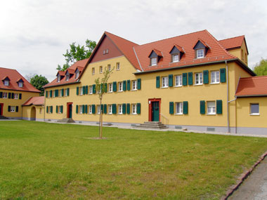 kleines Bild - Fassade Otto-Hahn-Platz 8-9 in Bitterfeld hat 10 Wohnungen, 2 RWE, 40 - 49 m<sup>2</sup>, altengerechte Bäder mit bodengleicher Dusche  vorhanden, Fernwärme, Stellplatz oder Garage möglich. Nebengelass in Verbinderbauten bzw. Dachgeschoss. Viel Grün und Gartennutzung möglich. Mehrere Garagenkomplexe im Wohngebiet vorhanden.