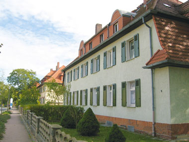 kleines Bild - Vorgarten Ignatz-Stroof-Straße 3-4 in Bitterfeld hat 4 Wohnungen, 3 RWE, 80 - 120 m<sup>2</sup>, Fernwärme, Stellplatz oder Garage möglich. Nebengelass im Dachgeschoss. Viel Grün und Gartennutzung möglich. Mehrere Garagenkomplexe im Wohngebiet vorhanden.