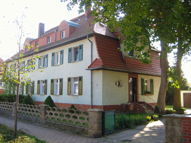 kleines Bild - Fassade Ignatz-Stroof-Straße 3-4 in Bitterfeld hat 4 Wohnungen, 3 RWE, 80 - 120 m<sup>2</sup>, Fernwärme, Stellplatz oder Garage möglich. Nebengelass im Dachgeschoss. Viel Grün und Gartennutzung möglich. Mehrere Garagenkomplexe im Wohngebiet vorhanden.