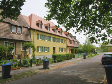 kleines Bild - Eingang Stefan-Simon-Straße 34 in Bitterfeld hat 4 Wohnungen, 2 RWE, 44 - 50 m<sup>2</sup>, Fernwärme, Stellplatz oder Garage möglich; Flächendenkmal. Nebengelass im Dachgeschoss. Viel Grün und Gartennutzung möglich. Mehrere Garagenkomplexe im Wohngebiet vorhanden.