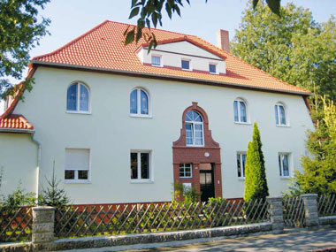 kleines Bild - Fassade Stefan-Simon-Straße 1 in Bitterfeld hat 4 Wohnungen, 2 - 3 RWE, 54 - 66 m<sup>2</sup>, mit Garten, Fernwärme, Stellplatz oder Garage möglich. Nebengelass im Dachgeschoss. Viel Grün und Gartennutzung möglich. Mehrere Garagenkomplexe im Wohngebiet vorhanden.